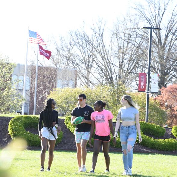 Students walk across the campus mall in summertime