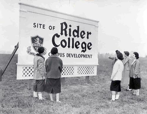 Coeds observe the Rider College sign during the groundbreaki