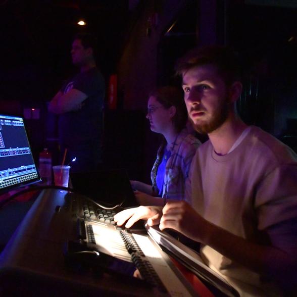 Student sits at mixing board during performance