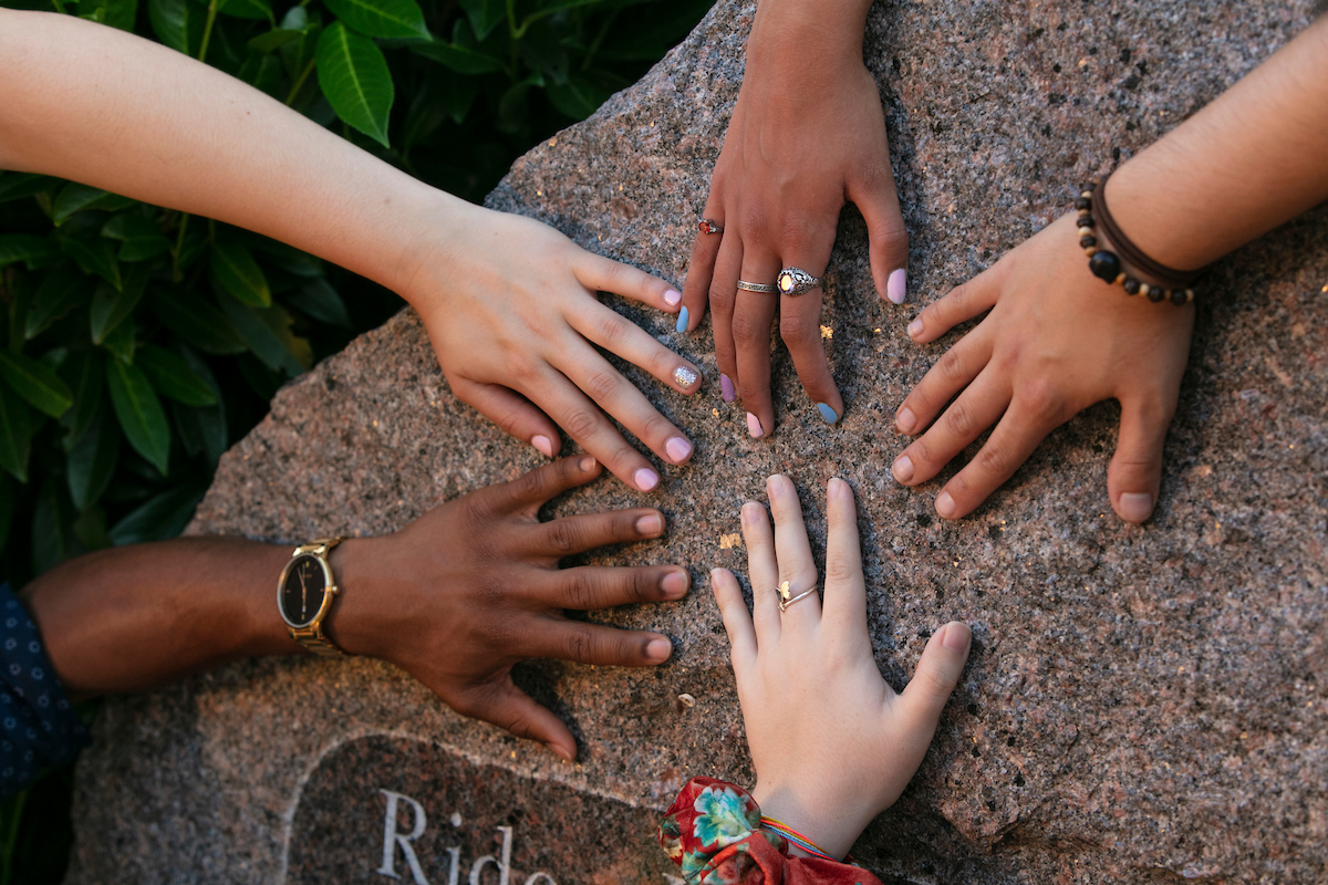 A variety of students' hands on the Rider Rock