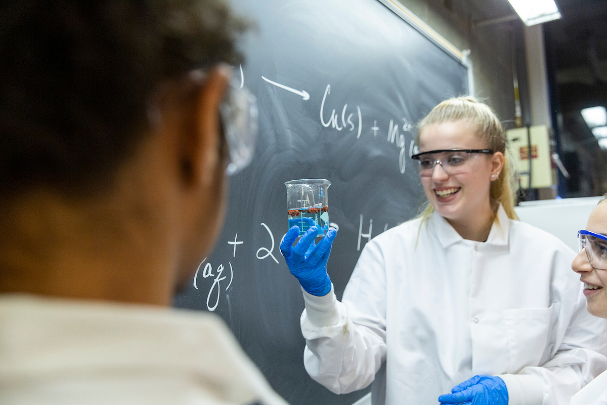 Female student holds up beaker 