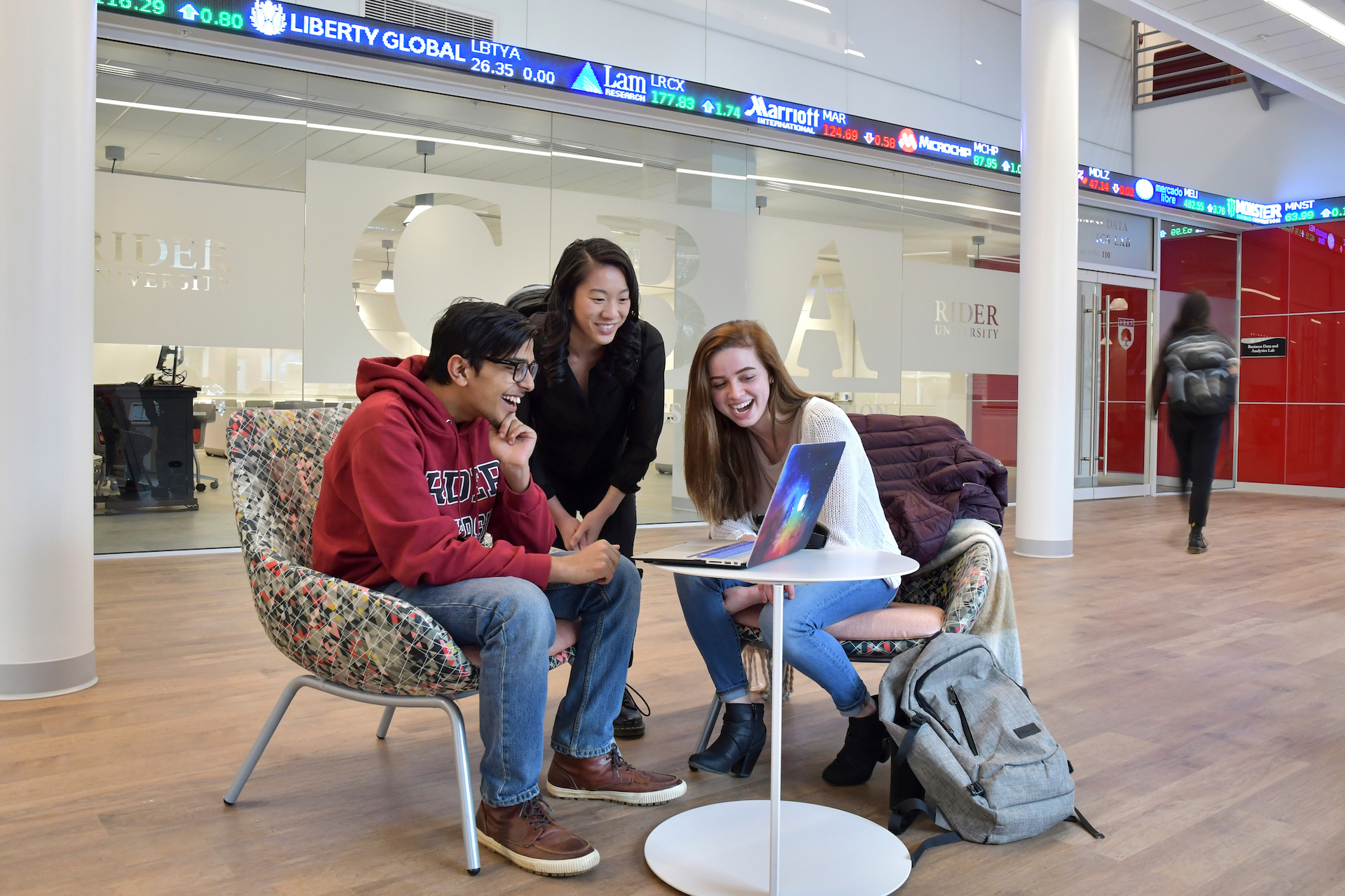 Three students watch video on laptop