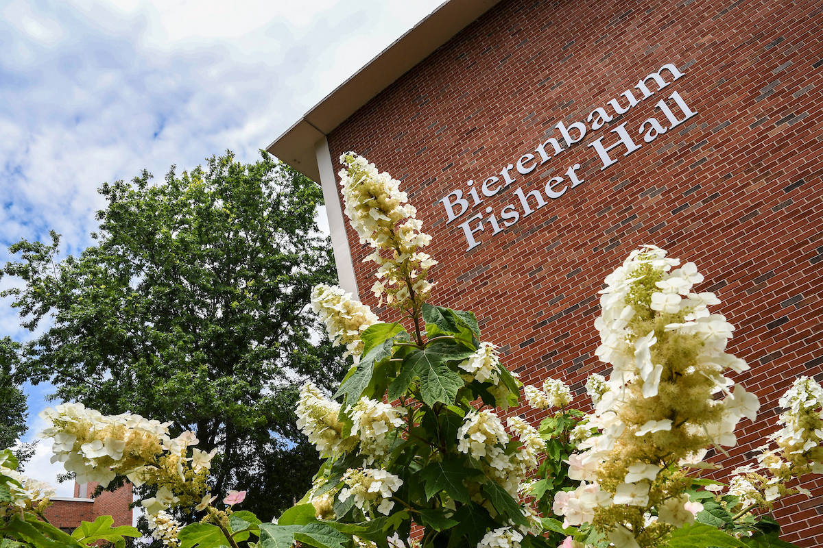 Education building with flowers in front of it.