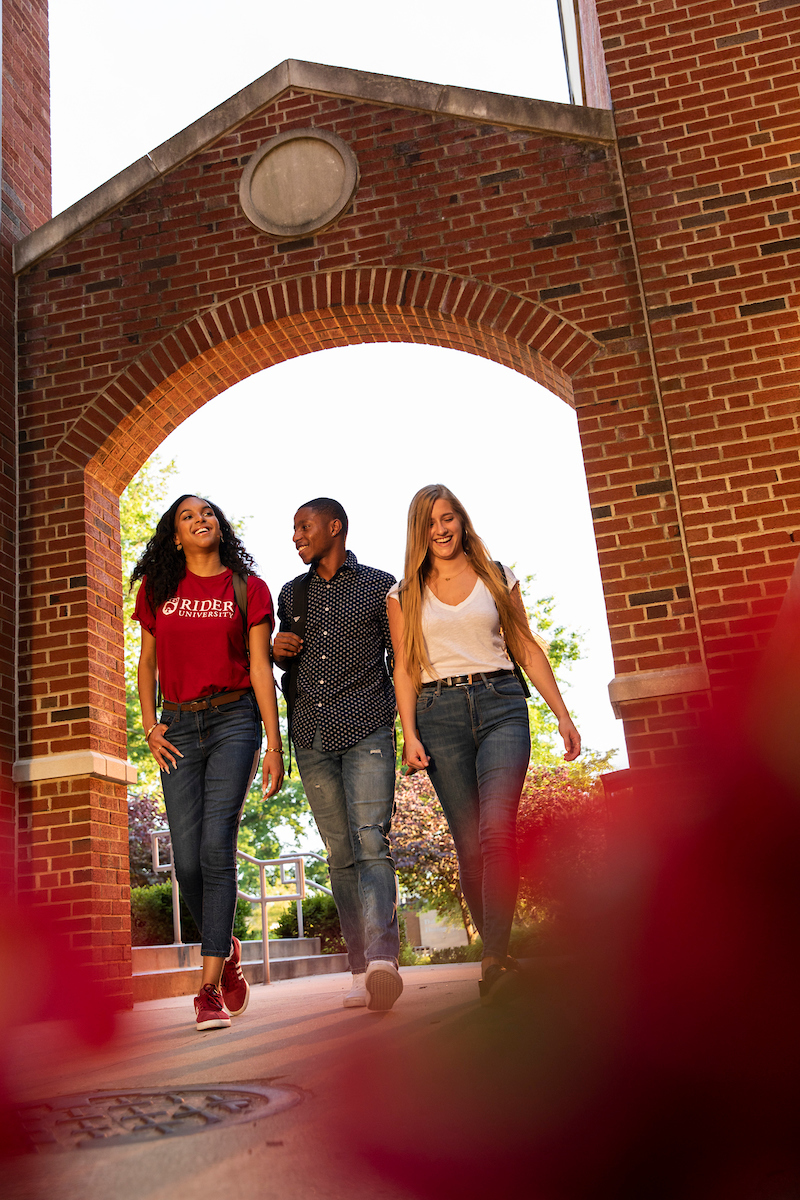 Students walk under archway on Rider campus