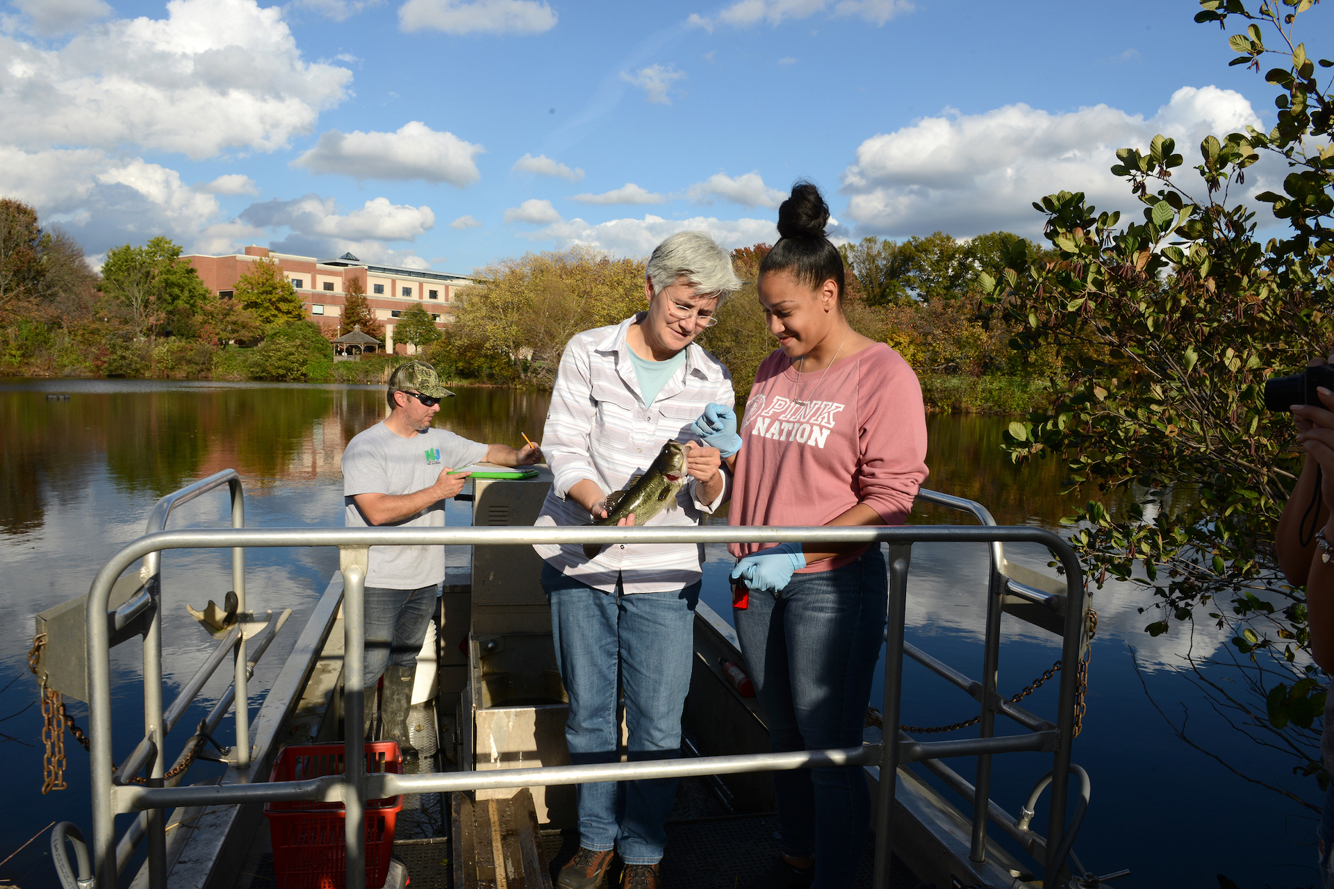 Student and faculty on a boat on Centennial Lake doing research