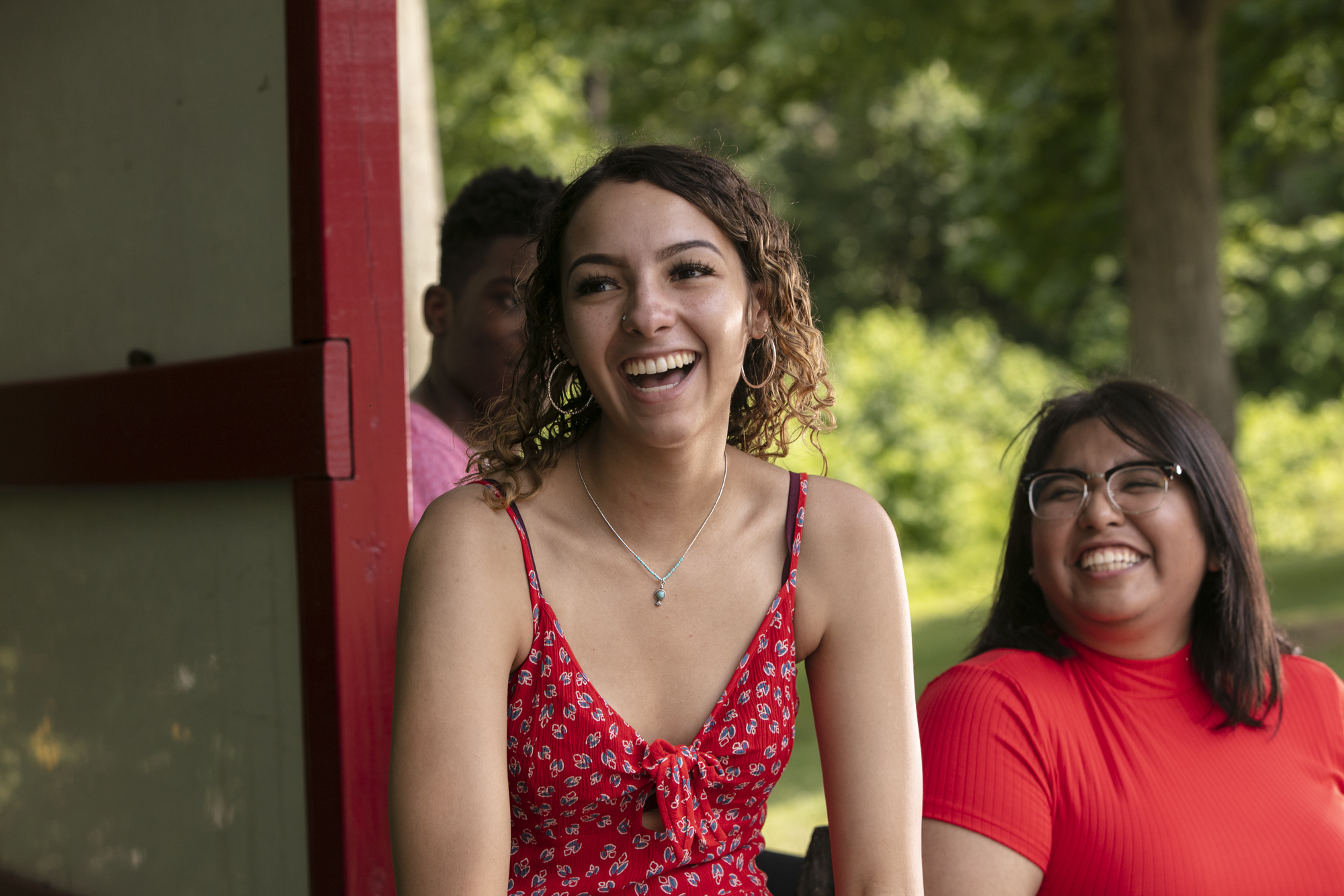 Students laugh while sitting outside