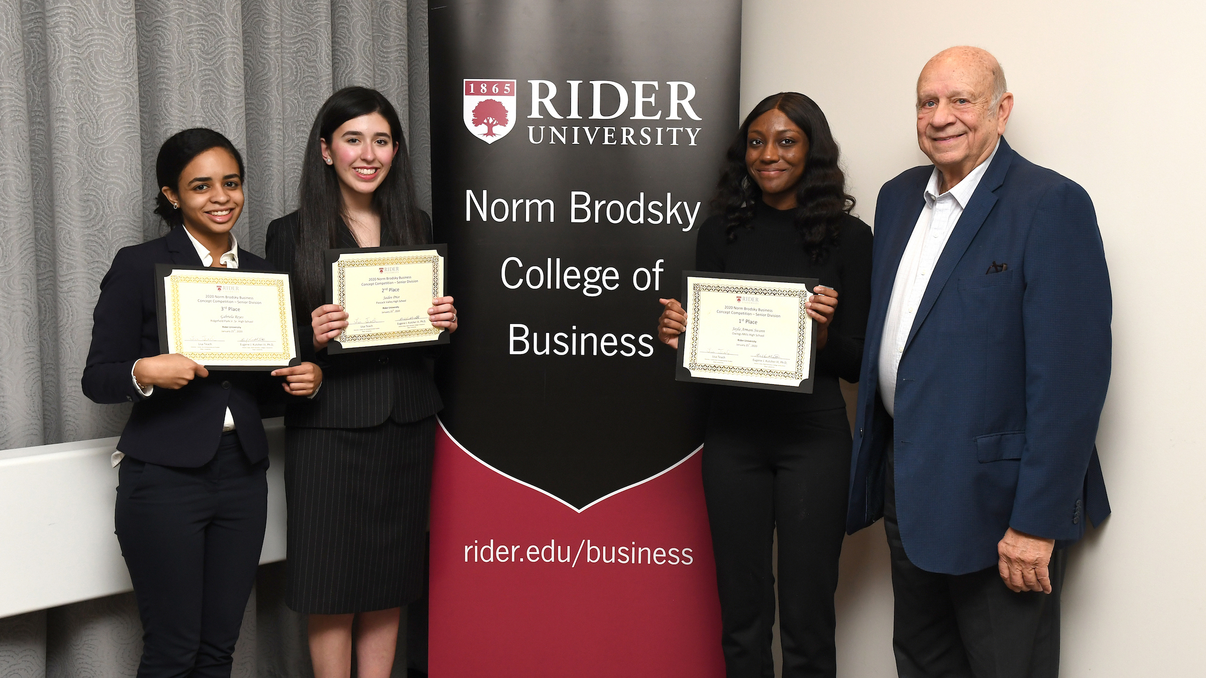 Three students pose with Norm Brodsky at competition