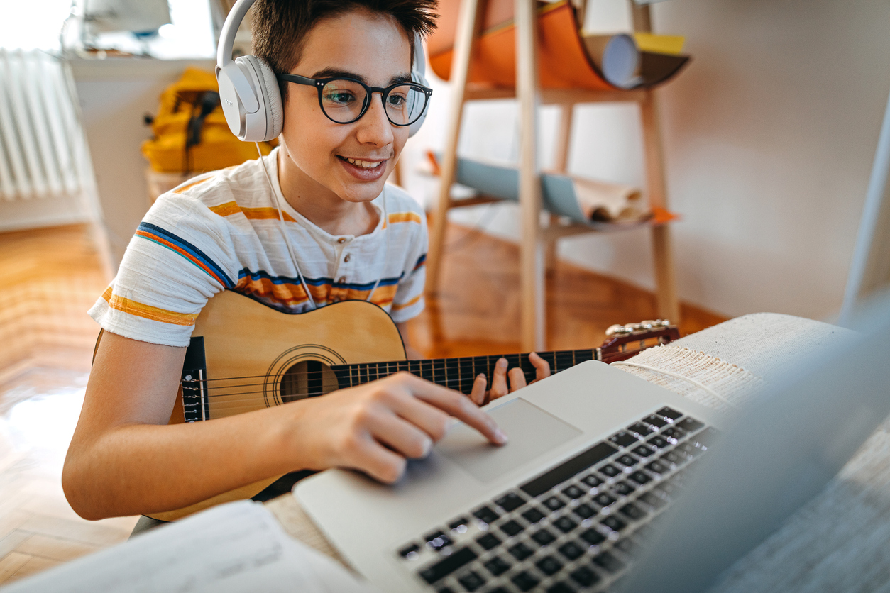 Student takes online guitar lesson