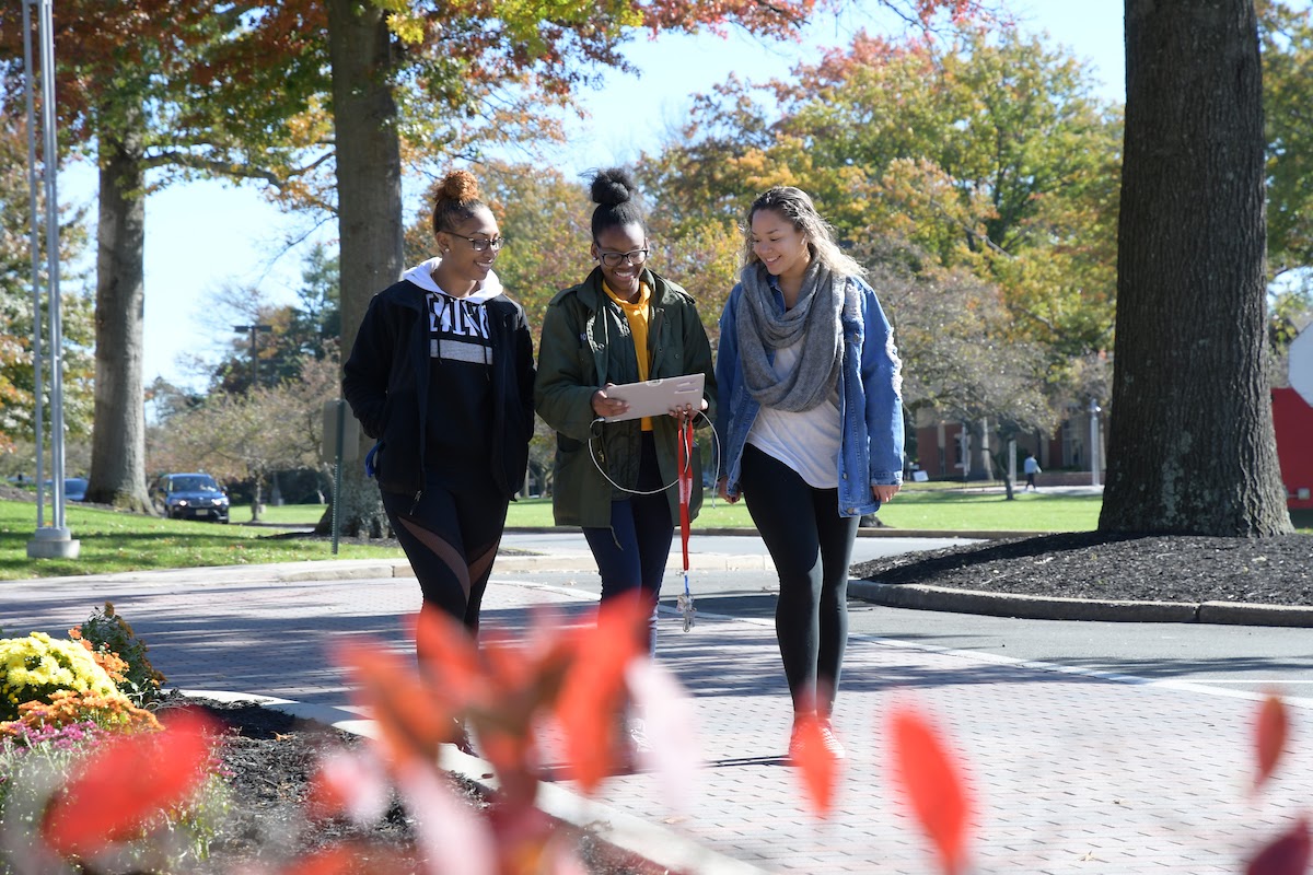 Three students walk together on campus