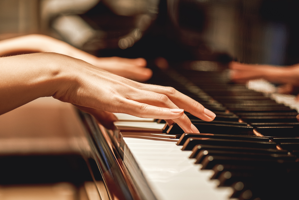 Closeup of woman playing piano.