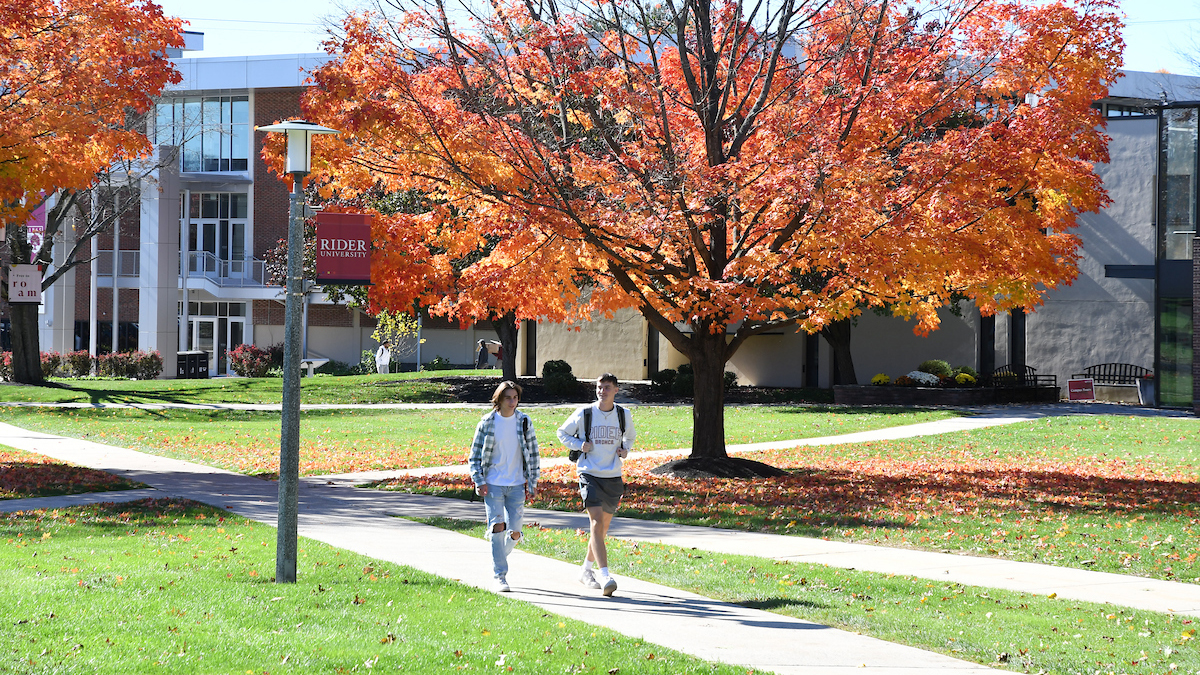 two students walking through campus on a fall day