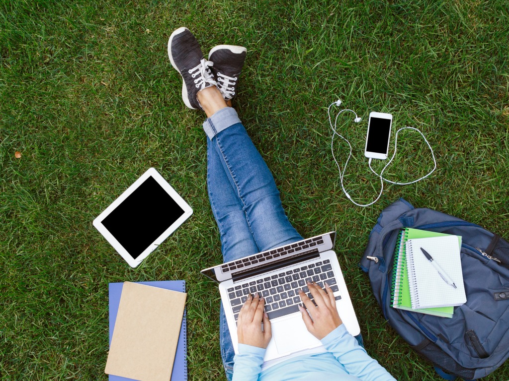 Student works outside on laptop 