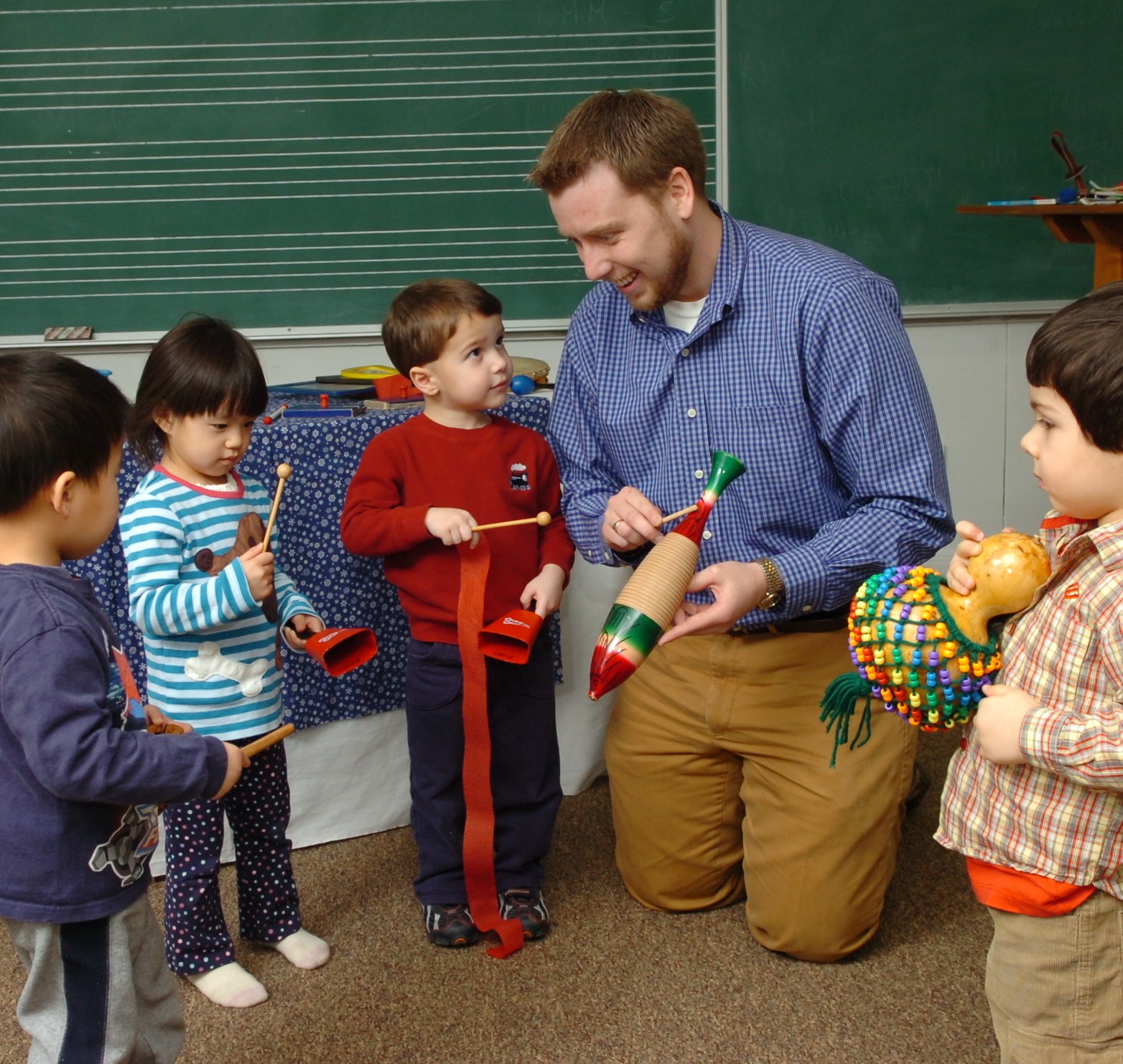Conservatory early childhood teacher with children and percussion instruments