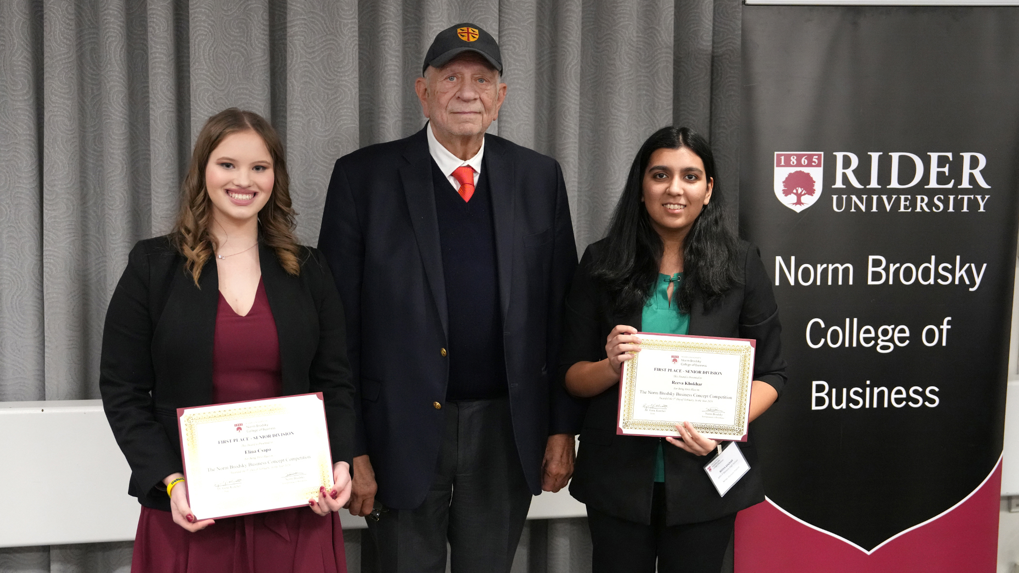 Norm Brodsky poses with two students at business competition