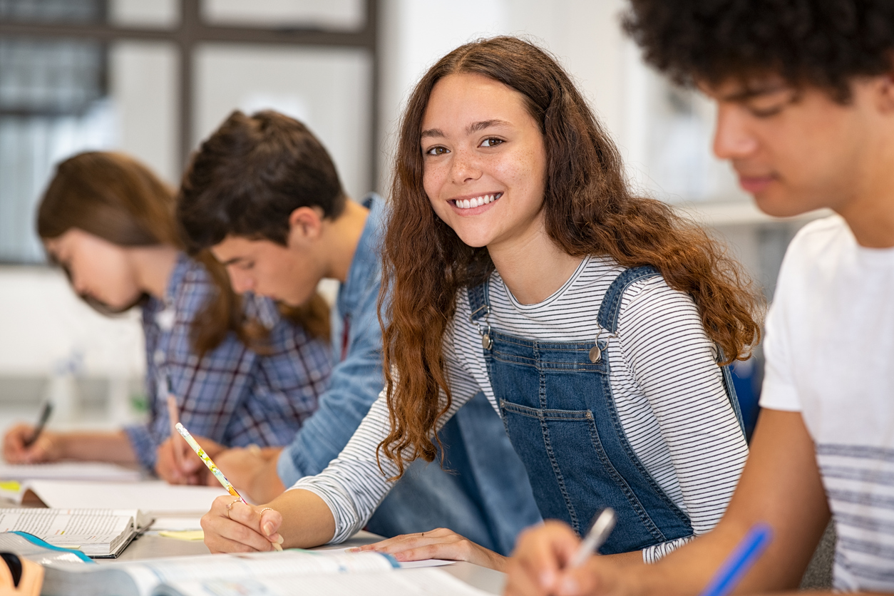 young high school students writing at a table