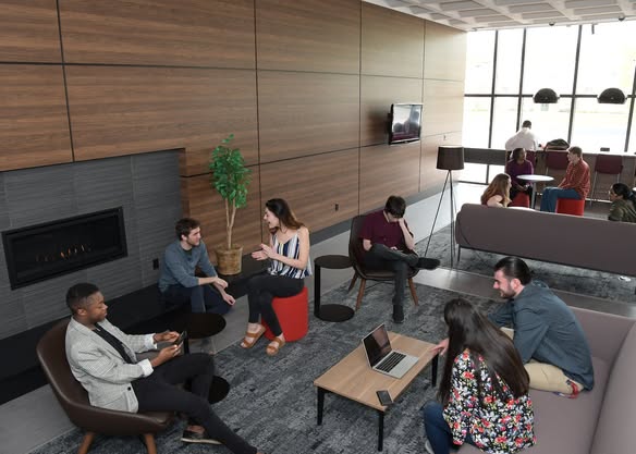 A diverse group of students sits in the Commuter Lounge.