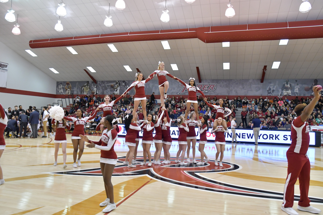 Cheerleaders cheer at basketball game.