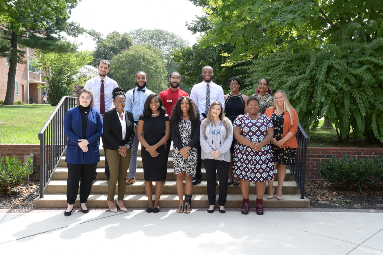 Graduate Assistants pose for photo on steps.