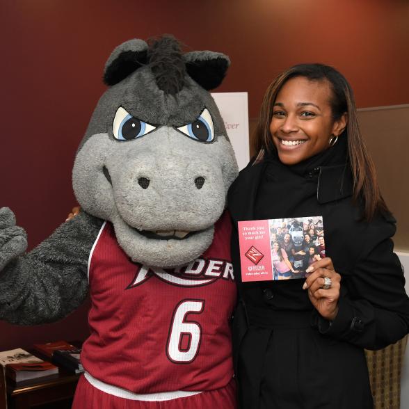 Rider mascot with Advancement staff member