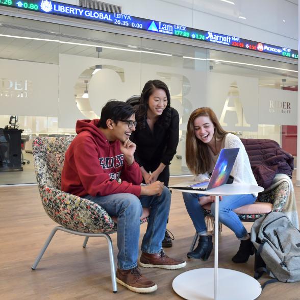 Three students watch video on laptop