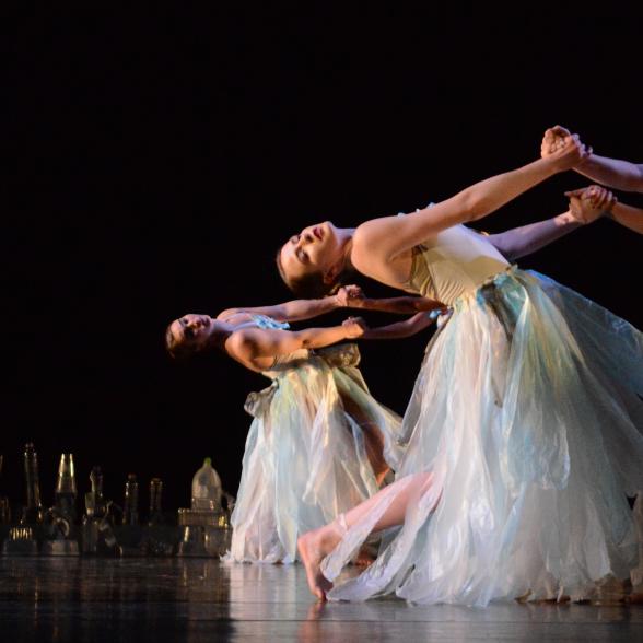 Image of dancers performing on stage in flowing dresses