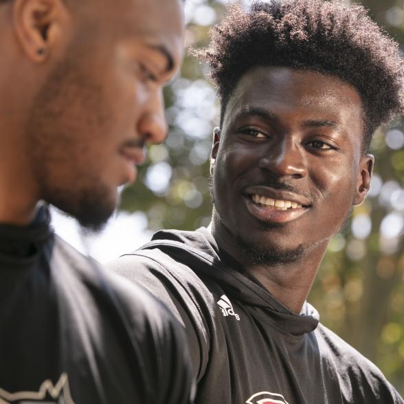 Student athletes talk in front of alumni gym