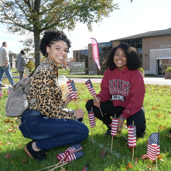 Alumni plant flags during Family Weekend