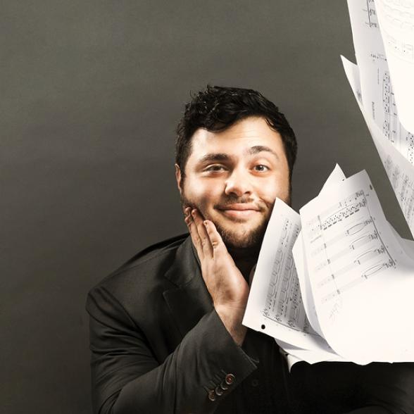 Alumnus poses for photo with sheet music.