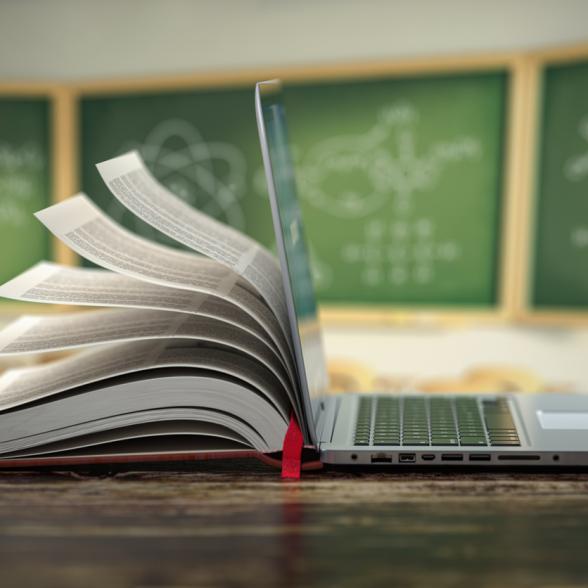 Book mingled with laptop in classroom