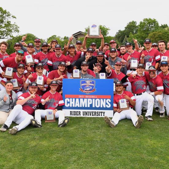 Men's baseball team poses with "Champions" sign