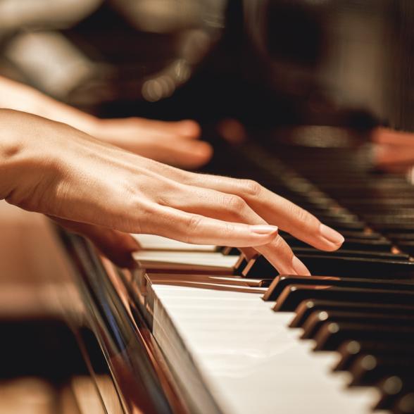 Closeup of woman playing piano.