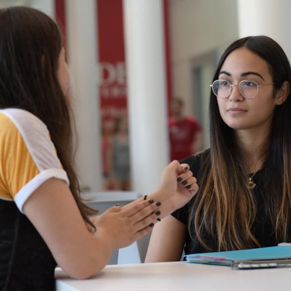 Two students talk together in lobby