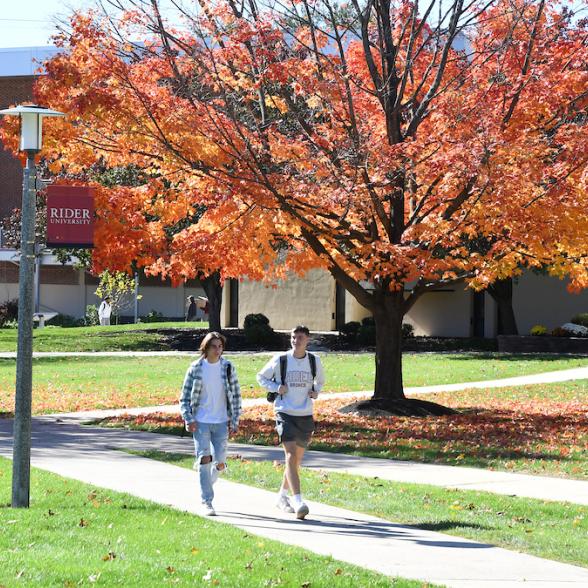 two students walking through campus on a fall day