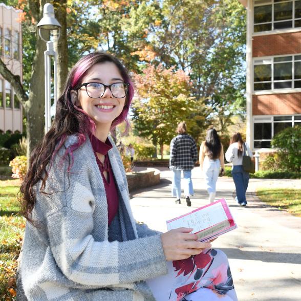 Smiling student reads a book