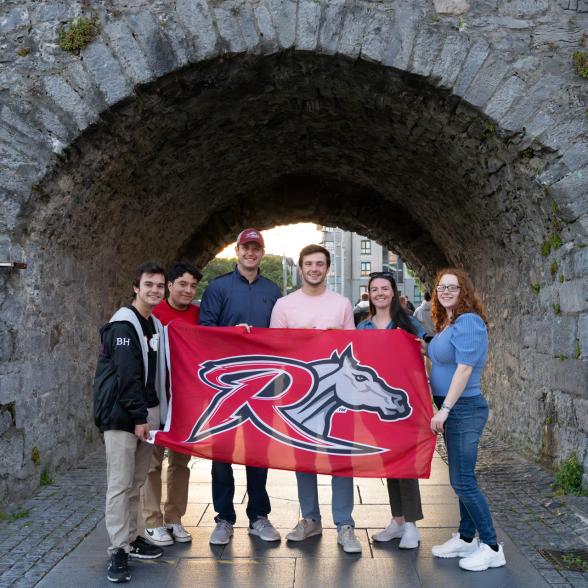 Study Abroad Business students with Rider flag 