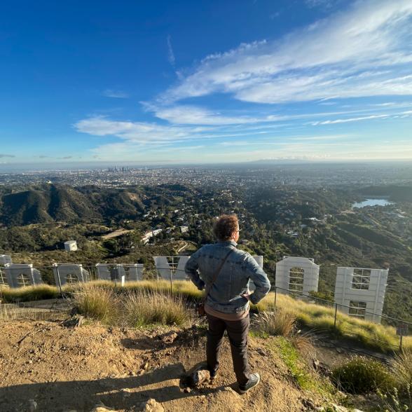 Student standing behind Hollywood sign looking out