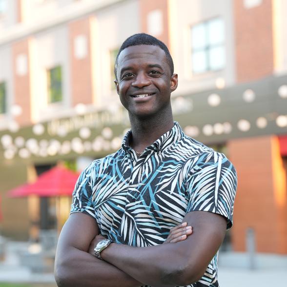 male graduate student smiling at camera in front of Swiegart Hall
