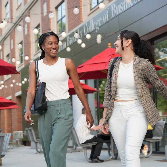 Two graduate students talk as they leave Sweigart Hall