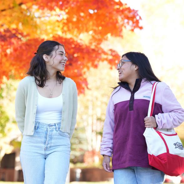 two students walking on campus in the fall