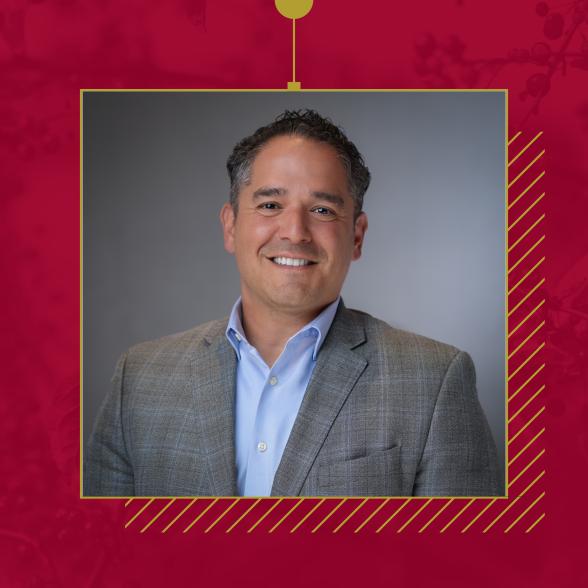 Carlos Dotrait Rider University Board Chair headshot in a gray suit and blue shirt