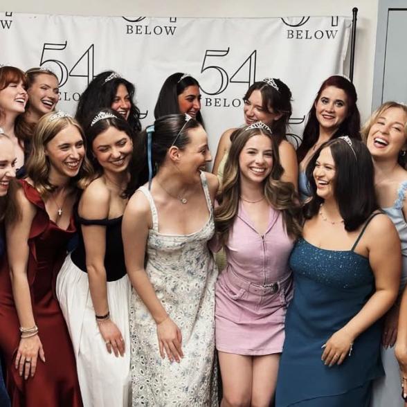 A group of women wearing crowns smiles and poses at 54 below