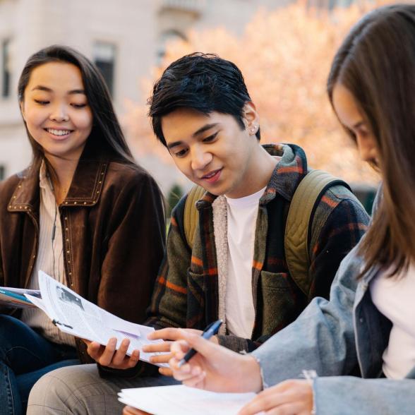 Students looking at papers outside