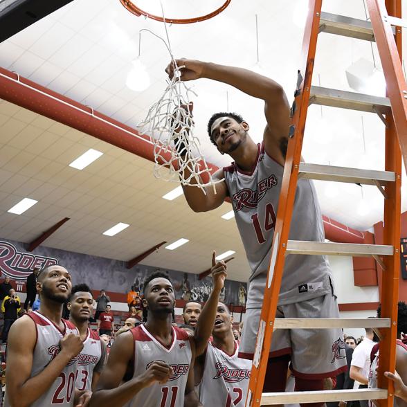 Men's basketball team cuts down the nets after beating Iona