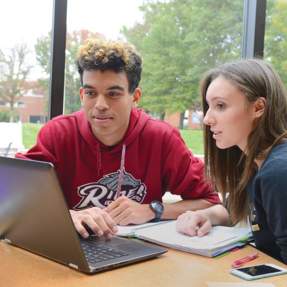 Two students use laptop