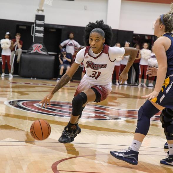 Basketball player dribbles down the court.