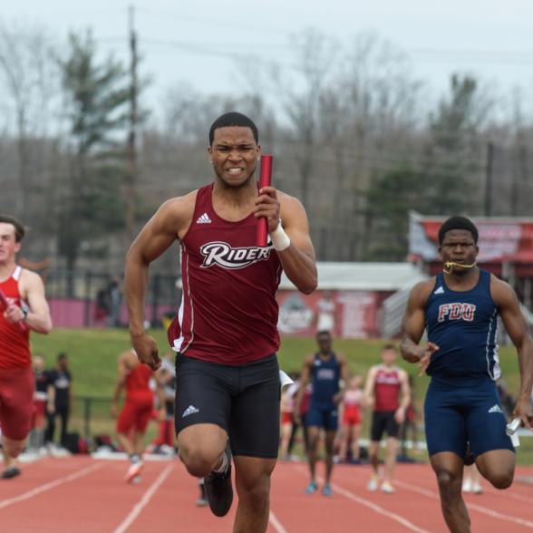 Runner runs in relay race at meet.