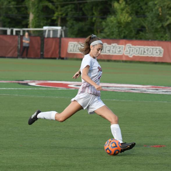 Soccer player kicks ball.