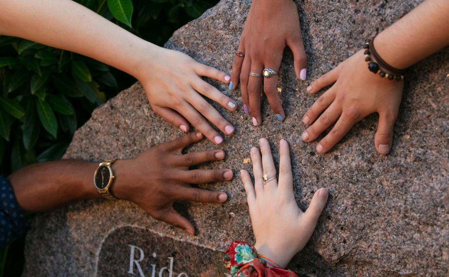 A variety of students' hands on the Rider Rock