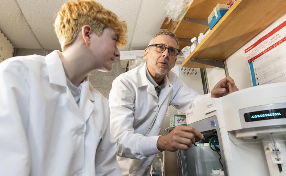 Student working with professor in science lab