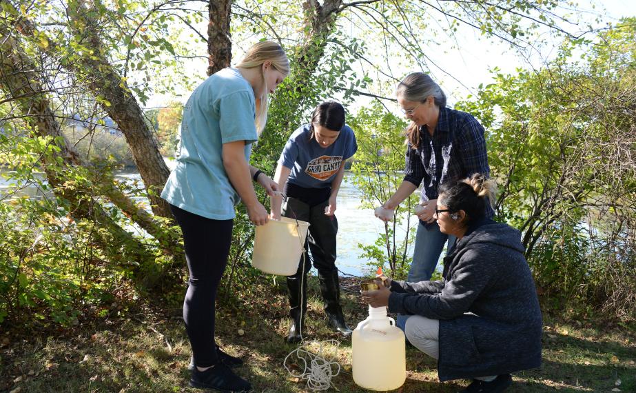 Group of students getting samples of water outdoors